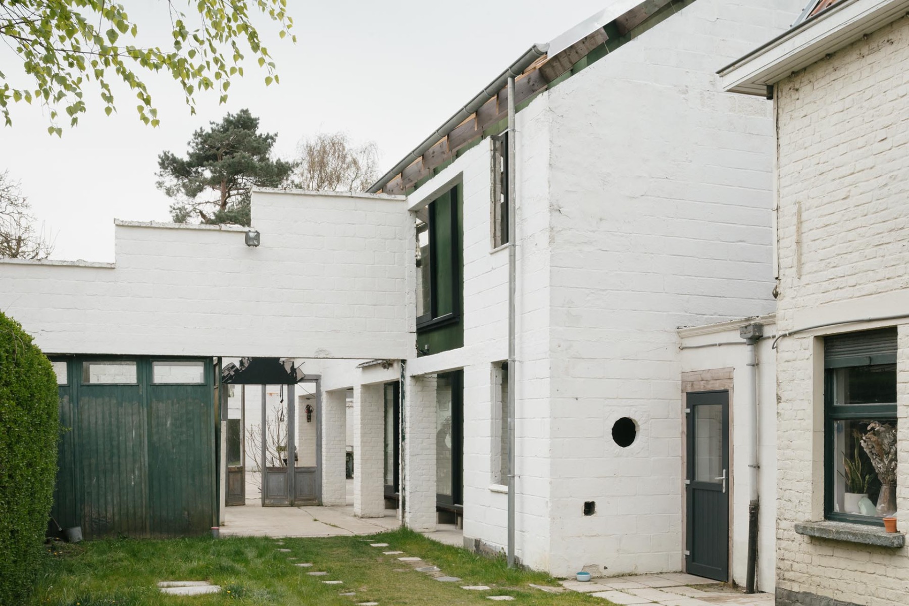 Innerhalb der Au&szlig;enmauern der alten Schreinerei liegt das neue Holzhaus. &copy; Stjin Bollaert